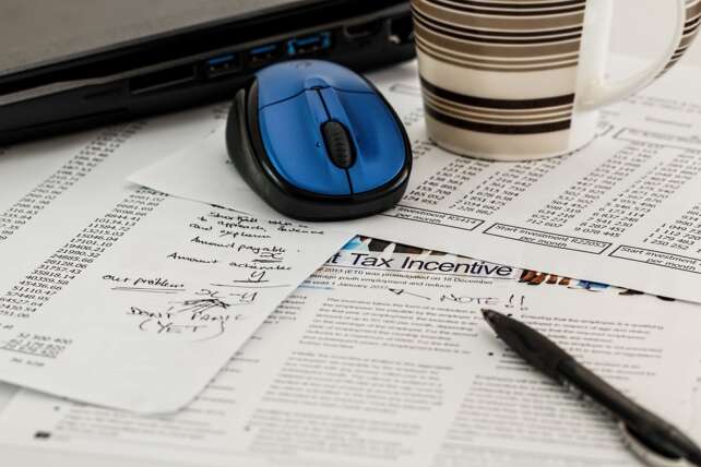 mouse and coffee cup and pen on Canadian tax filing notepad