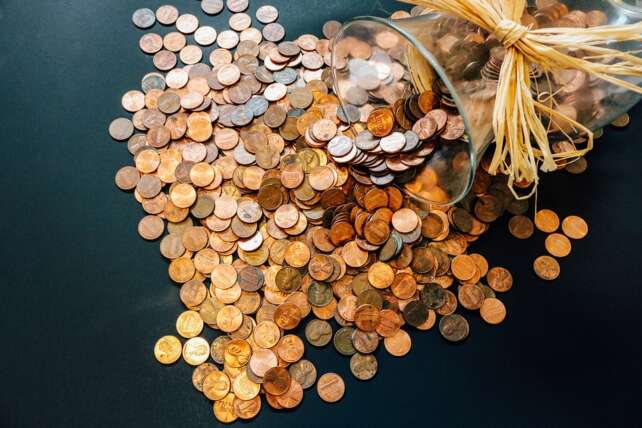 pennies spilled on a table to pay debt or to invest