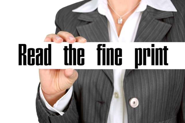 businesswoman holding a read the fine print sign