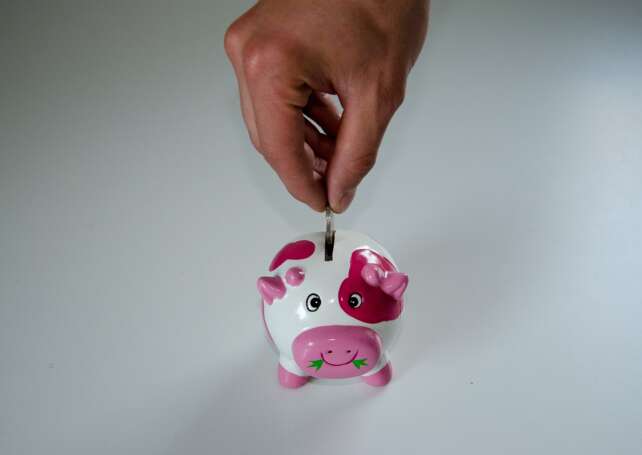 a coin being inserted in a piggybank, representing the rise of interest rates in Canada and its consequences on debt